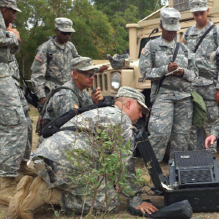 RMV Technologies is one of the few companies that offers hands-on training for best practices in avoiding electrostatic discharge during manufacturing, handling, and storage of sensitive electronics. Their seminar benefited from input from NASA, and is now being offered widely. The U.S. military is one customer. Image courtesy of U.S. Army Service members crowd around field communication equipment