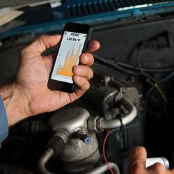 Mechanic using diagnostic tool on car engine