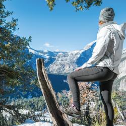 A woman on a mountain trail wearing Oros aerogel-lined outerwear