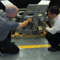 A payload specialist trains a researcher on how to pack payloads