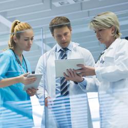 Doctors conferring while looking at a tablet computer