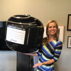 Woman holds large composite overwrapped pressure vessel easily in one hand