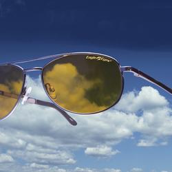 Amber lens aviator sunglasses with a sunny blue sky backdrop