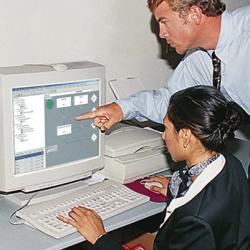 Man pointing to woman's computer screen with QRAS software displayed