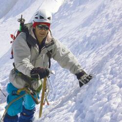 A mountain climber leans on a snowy slope