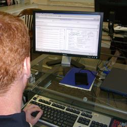 View over a user’s shoulder of AIOXFinder software displayed on a monitor