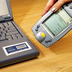 a hand-held device scanning a bar code on a laptop computer