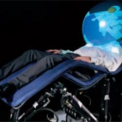 A man sits in a relaxation chair with his head inside of a bubble dome