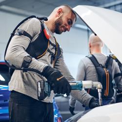Swedish company Bioservo Technologies’ Ironhand robotic glove being used with a power tool under a car hood