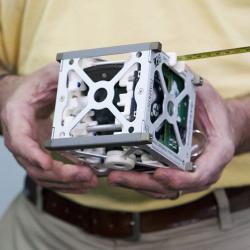 A CubeSat held in a man's hands