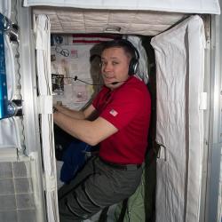 An astronaut in his sleeping cabin