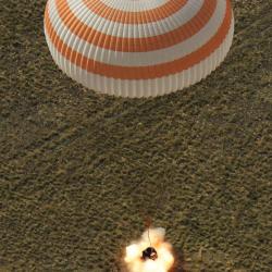 A Soyuz capsule landing with parachute