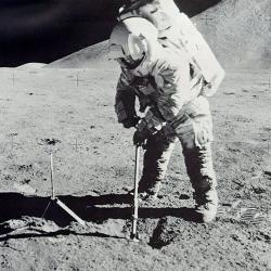 astronaut on moon scoops soil sample