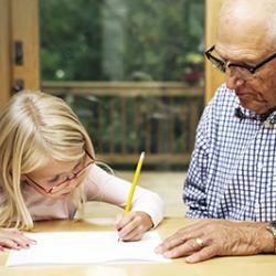 Man helping granddaughter with homework