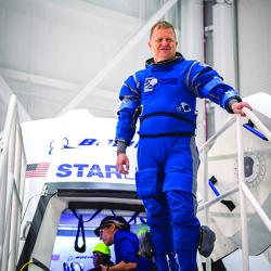 Crew member stands outside the Boeing Starliner spacecraft