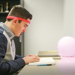 A student reading while wearing BrainCo’s LUCY headband