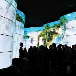Organic LED, or OLED, displays are known for their rich colors and deep blacks, as well as for being thin and often flexible. But they’re also expensive. Manufacturers are working to bring down the cost by applying the screens’ organic dyes via inkjet printer, a process that uses Artium’s spray characterization technology for quality control. Waterfalls displayed across multiple OLED screens in an elaborate curved arrangement