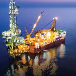 An offshore oil platform is lit up at night