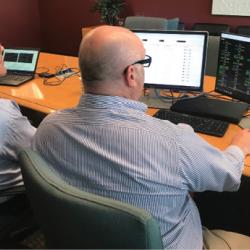 Mosaic CEO Chris Brinton and a retired air traffic coordinator look at a computer